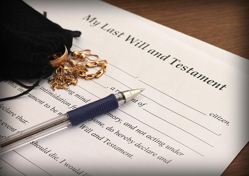 Last Will and Testament form with gold jewelry, close-up