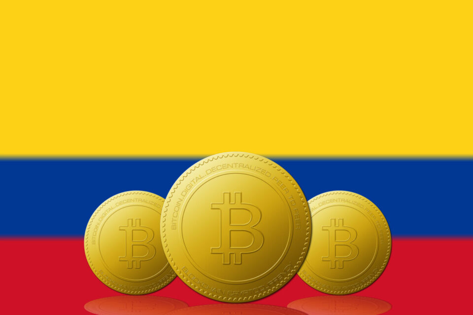 Three Bitcoins cryptocurrency with COLOMBIA flag on background.