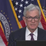 Global financial markets under stress as the Iran conflict drives oil price spikes, with inflation charts rising and central bank imagery highlighting pressure on the Federal Reserve’s ability to keep inflation expectations anchored.