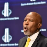 South Africa central bank maintaining interest rates amid rising inflation fears, with charts showing bond yields and fuel price increases driven by the Iran conflict and global oil surge.