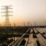 Global renewable energy expansion illustrated with solar panels and wind turbines, alongside rising capacity charts showing 692GW growth in 2025, signaling a powerful surge in clean energy adoption worldwide.