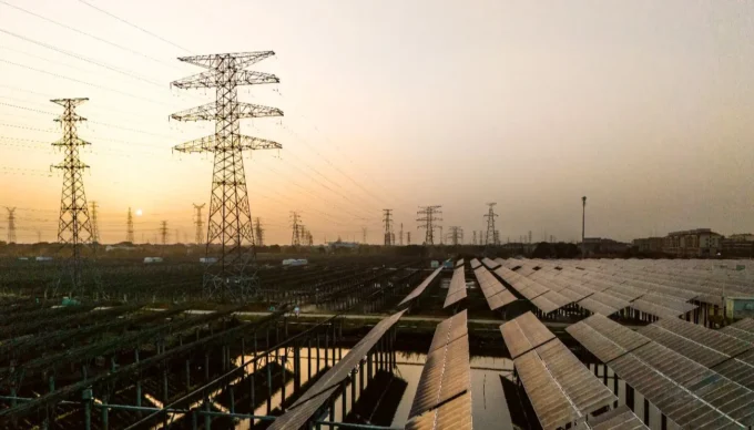 Global renewable energy expansion illustrated with solar panels and wind turbines, alongside rising capacity charts showing 692GW growth in 2025, signaling a powerful surge in clean energy adoption worldwide.