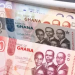 Ghana cedi banknotes in a cash-counting machine, representing Ghana fixed deposit rates, local savings, and Treasury bill yield comparisons.