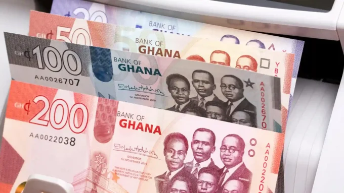 Ghana cedi banknotes in a cash-counting machine, representing Ghana fixed deposit rates, local savings, and Treasury bill yield comparisons.
